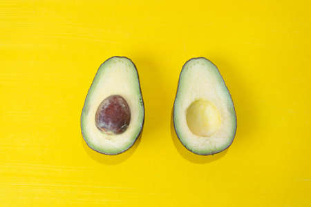 Fresh avocado halves on colorful background