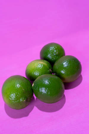 Set of green limes on colorful background