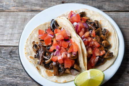 Vegan and vegetarian mexican mushrooms tacos with sauce and lime in flour tortillasの写真素材