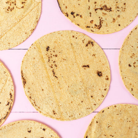 Tasty mexican corn tortillas on pink background