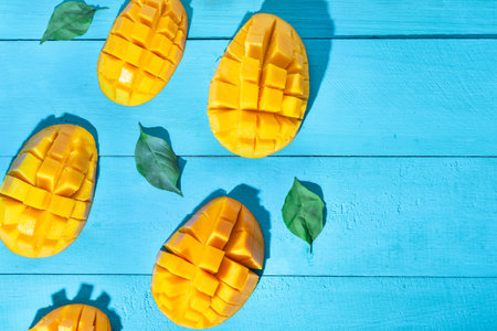 Tasty exotic mango tropical fruit cutted on blue backgroundの写真素材
