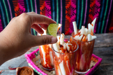 Mexican jicama fruit cutted with green lime, chili powder and chamoy