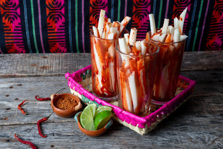 Mexican jicama fruit cutted with green lime, chili powder and chamoy