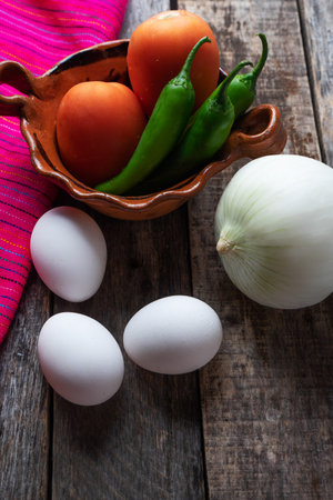 Mexican eggs recipe ingredients. White eggs, serrano pepper, onion and tomatoの写真素材