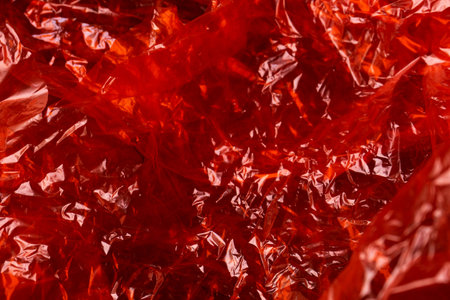 Red wrinkled cellophane paper background textureの写真素材