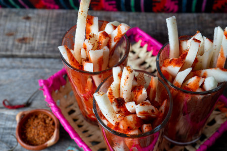Mexican jicama fruit cutted with green lime, chili powder and chamoy