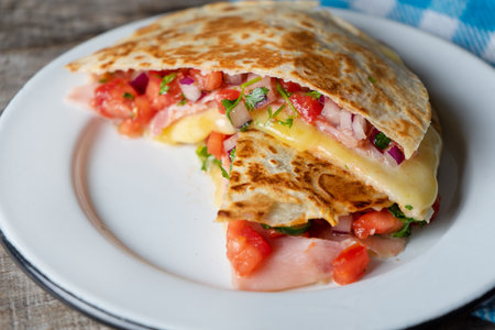 Traditional mexican quesadillas with sliced ham also called "synchronizadas" on wooden backgroundの写真素材