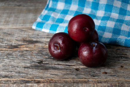 Fresh and juicy plums on wooden backgroundの写真素材