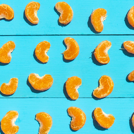 Peeled segments of tangerine on blue background