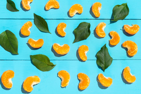 Peeled segments of tangerine on blue background