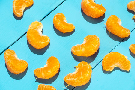Peeled segments of tangerine on blue backgroundの写真素材