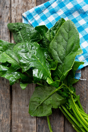 Raw and fresh spinach on wooden backgroundの写真素材