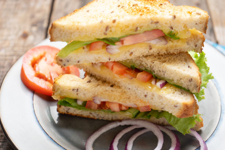 classic grilled cheese sandwich with tomato and whole grain bread on wooden backgroundの写真素材