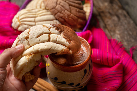 Traditional mexican hot chocolate with sweet conchas bread on wooden backgroundの写真素材