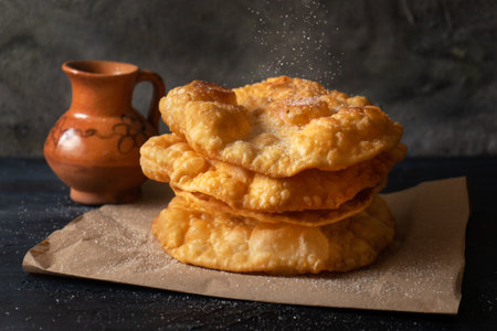Traditional mexican fritter dusted with sugar also called "buÃ±uelos" on dark backgroundの写真素材