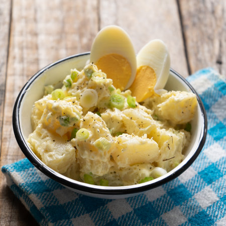 Traditional potato salad with egg and mayonnaise on wooden backgroundの写真素材