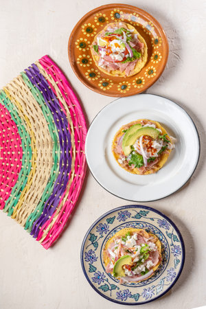 Traditional mexican ham toast also called tostadas with beans and cheese on white backgroundの写真素材