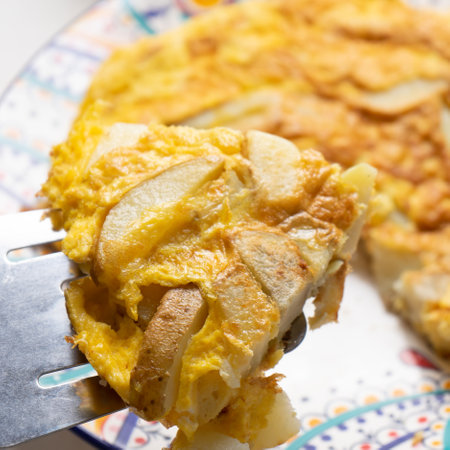 Traditional spanish scrambled eggs with potatoes called tortilla or tapa on white backgroundの写真素材