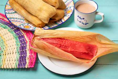 Traditional mexican sweet tamales with strawberry jam on turquoise backgroundの写真素材