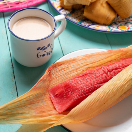 Traditional mexican sweet tamales with strawberry jam on turquoise backgroundの写真素材