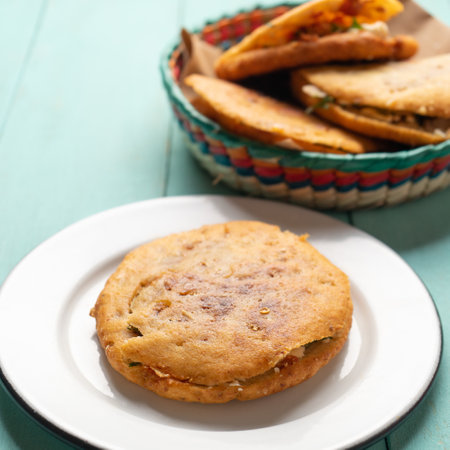 Traditional mexican gorditas with pressed chicharron on turquoise backgroundの写真素材