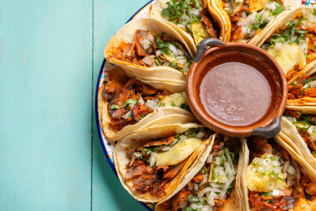 Traditional mexican pork tacos called "Al pastor" with pineapple on turquoise backgroundの写真素材