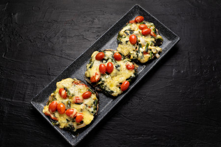 Portobello mushroom stuffed with spinach and cheese on dark backgroundの写真素材