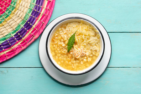 Traditional mexican corn grain boiled also called esquites with cheese and mayonnaise on turquoise backgroundの写真素材