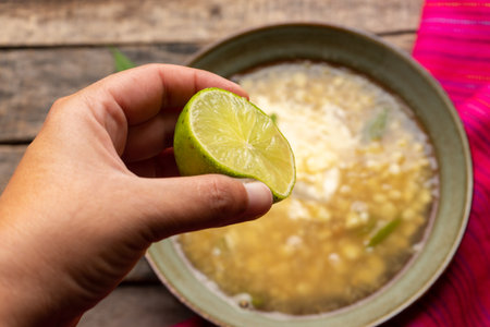 Traditional mexican corn grain boiled also called esquites with cheese and mayonnaise on wooden backgroundの写真素材