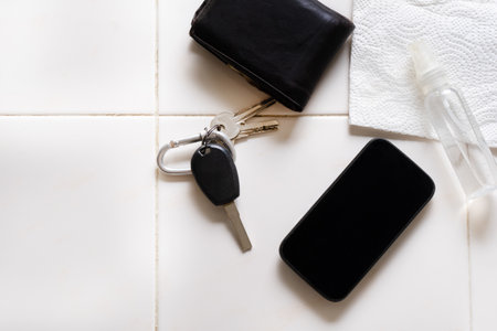 Keys, smartphone and plastic spray bottle with disinfectant on white backgroundの写真素材