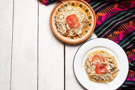Traditional mexican salbutes with shredded chicken on white background