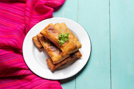 Traditional mexican chimichanga on turquoise background