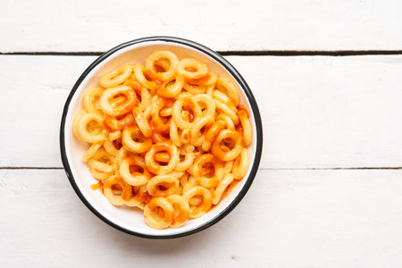 Rings of fried wheat with piquant sauce is a traditional mexican snack on white backgroundの写真素材
