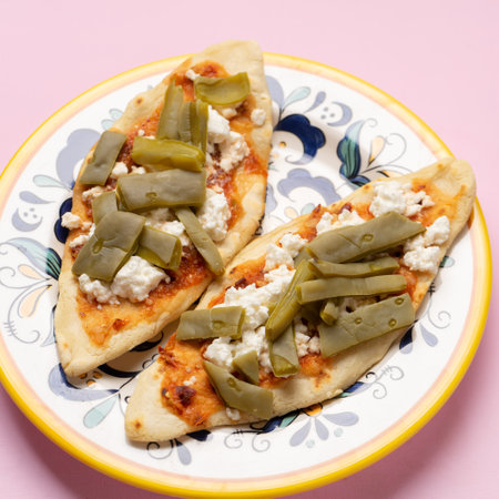 Traditional mexican tlacoyos with nopal cactus and cheese on pink background