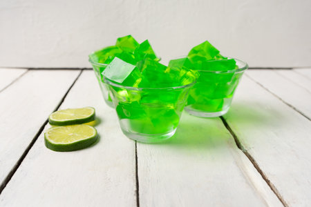 Bowl with lime jelly on white background