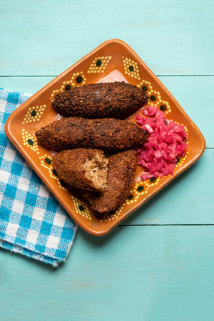 Traditional mexican kibi with meat and onion on turquoise backgroundの写真素材