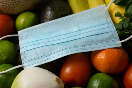 Raw vegetables, fruits and medical facial mask on wooden backgroundの写真素材
