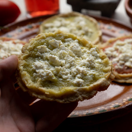 Traditional mexican picaditas with sauce and fresh cheese on white background