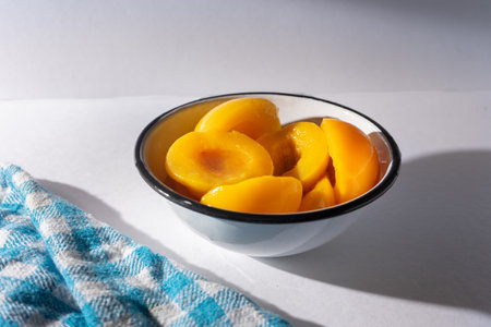 Traditional peaches in syrup on white backgroundの写真素材