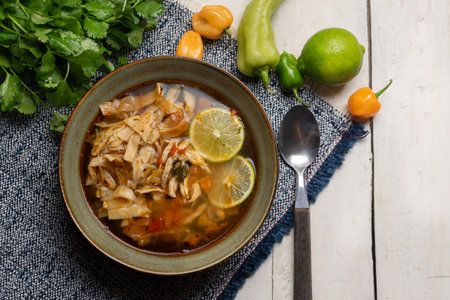 Traditional mexican lime soup with chicken on white background