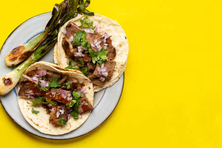 Traditional grilled beef steak tacos on yellow background. Mexican foodの写真素材
