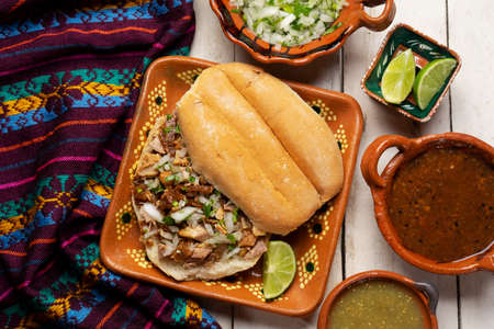 Confit pork sandwich called Torta de carnitas on white background. Traditional Mexican foodの写真素材