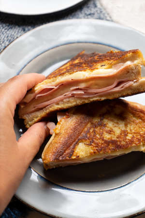 Traditional ham and melted cheese sandwich called Monte Cristo on white background