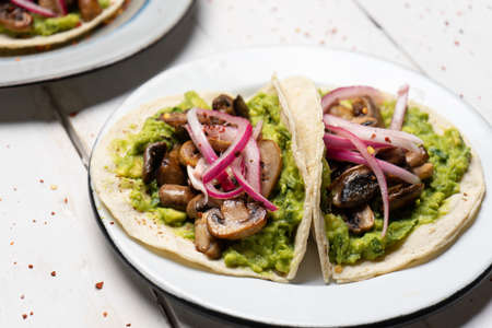 Mushroom and guacamole tacos on white background. Traditional mexican food