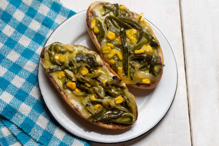 Molletes with poblano rajas and cheese on white background. Traditional mexican foodの写真素材