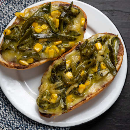 Molletes with poblano rajas and cheese on dark background. Traditional mexican foodの写真素材