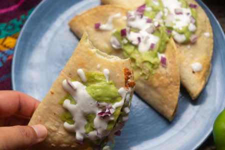 Fried tacos with guacamole and sour cream on wooden background. Traditional mexican foodの写真素材