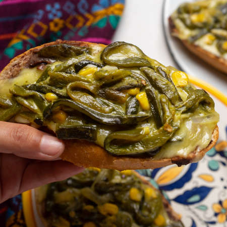 Molletes with poblano rajas and cheese on white background. Traditional mexican foodの写真素材