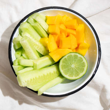 Fresh cucumber and mango salad on white backgroundの写真素材