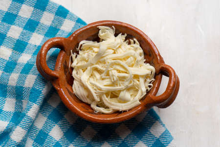 Shredded Oaxaca cheese also called quesillo on white background. Traditional mexican foodの写真素材